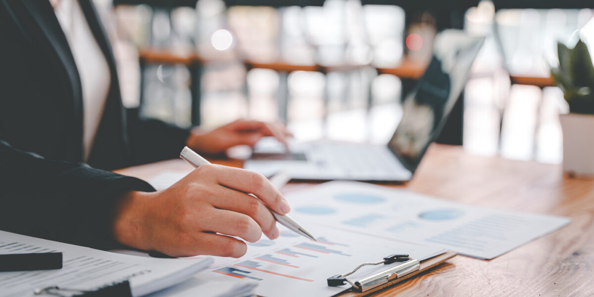 Concept per consigli per la gestione del lavoro come consulente immobiliare: close up su mani e dati cartacei. Replanner