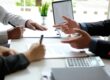 Concept per come ottenere un mutuo: close up su mani di persone che dialogano in un ufficio