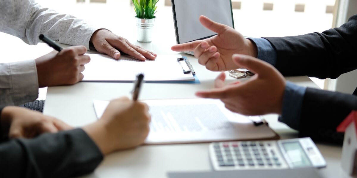 Concept per come ottenere un mutuo: close up su mani di persone che dialogano in un ufficio