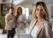 Concept come gestire la prima visita immobiliare: primo piano di donna consulente immobiliare e sullo sfondo due clienti