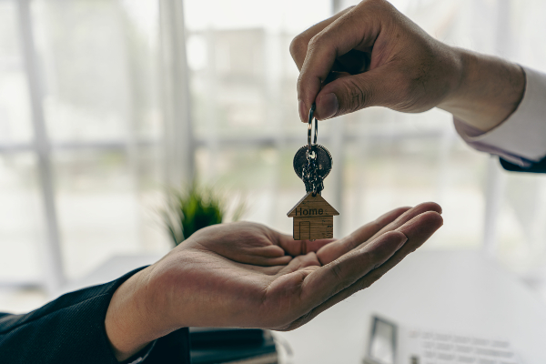 Concept come gestire la prima visita immobiliare: scambio di chiavi di un'abitazione tra consulente immobiliare e acquirente