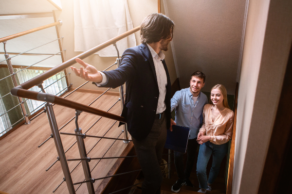 Concept come gestire la prima visita immobiliare: consulente immobiliare accompagna due clienti nella visita di un'abitazione