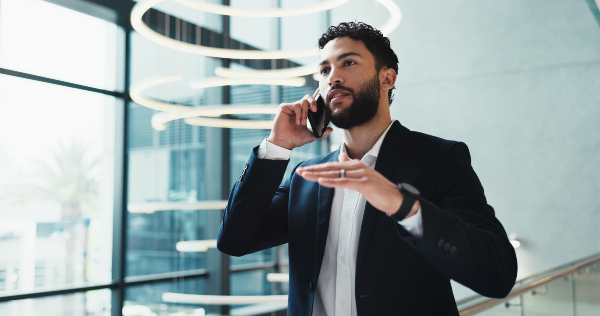 Concept per ''tecniche di negoziazione immobiliare'': consulente parla al telefono, gesticolando.