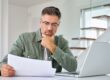Concept per ''Quanto costa davvero comprare casa?'': una persona guarda lo schermo di un computer, con aria pensierosa