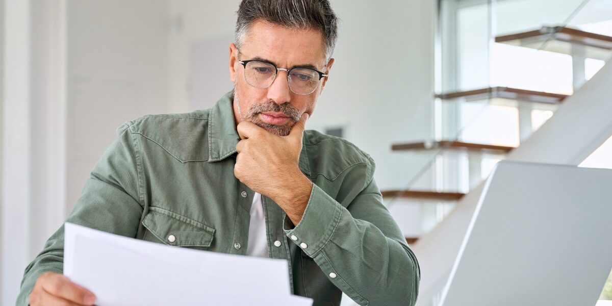 Concept per ''Quanto costa davvero comprare casa?'': una persona guarda lo schermo di un computer, con aria pensierosa