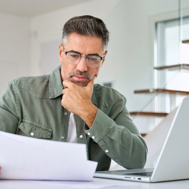 Concept per ''Quanto costa davvero comprare casa?'': una persona guarda lo schermo di un computer, con aria pensierosa