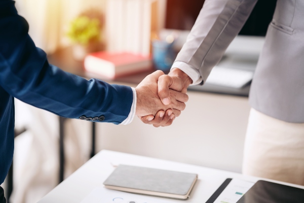 Concept per la gestione dei clienti nel settore immobiliare: stretta di mano tra consulente e cliente